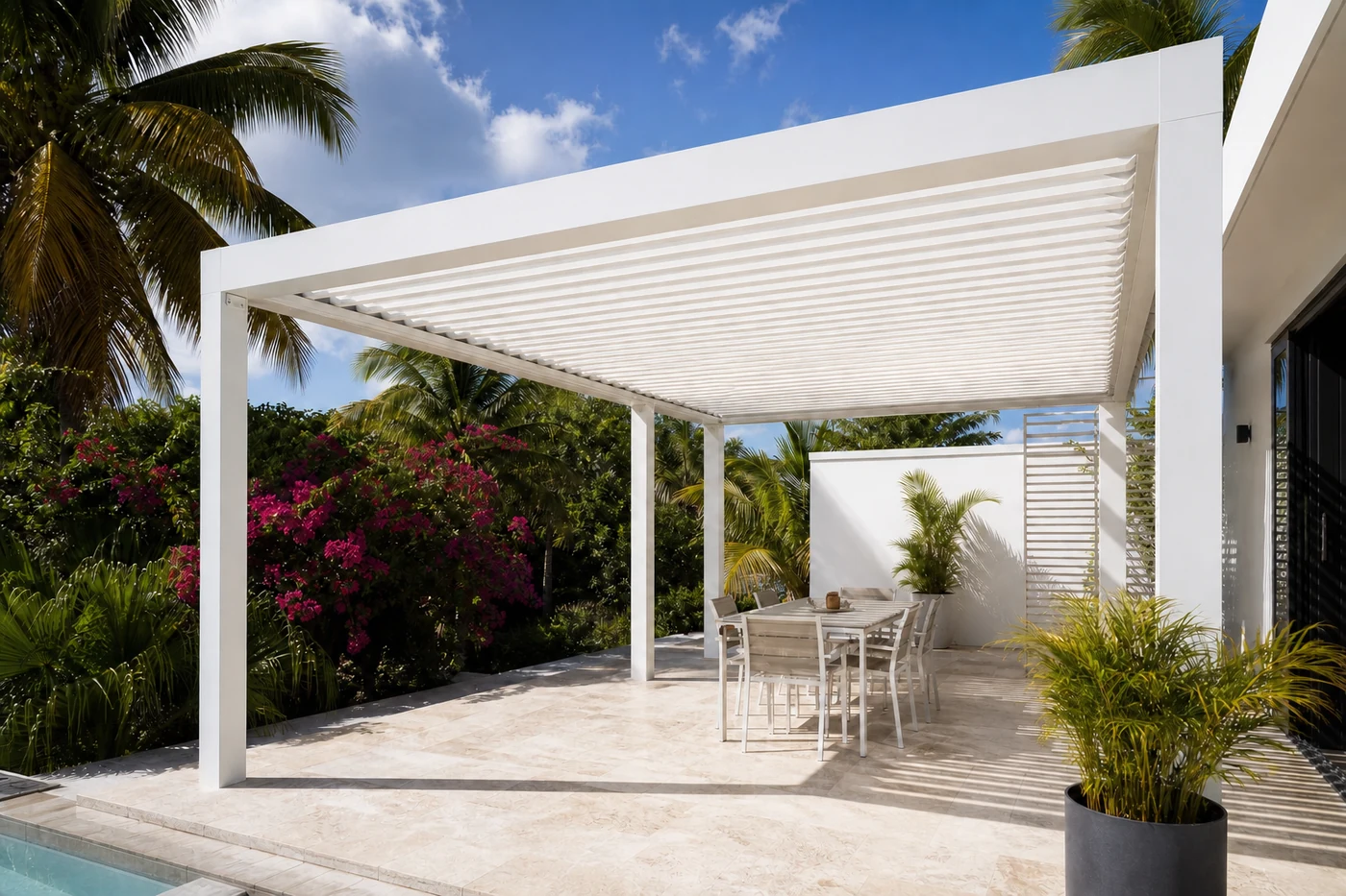 Pergola bioclimatique blanche 5x4 sur mesure sur une terrasse en pierre au bord de la piscine à Baie-Mahault, Guadeloupe — réalisation GT MAT